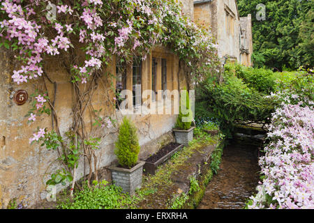 Le printemps dans les Cotswolds - un ruisseau s'écoulant en un cottage dans le village de Cotswold, Gloucestershire UK Stanway Banque D'Images