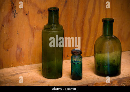 La vie toujours avec des bouteilles en verre de différentes formes sur une ancienne pharmacie étagère. Banque D'Images