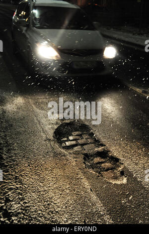 Francfort, Allemagne - August 14, 2010 - voiture roulant sur mauvaise route glacée et de nuit avec des nids de poule Banque D'Images