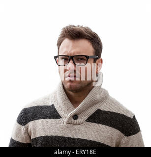 Portrait d'un beau jeune homme avec une expression de colère, sur un fond blanc. Banque D'Images