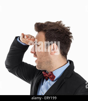 Profil d'un beau jeune homme avec un arc rouge regardant au loin sur un fond blanc. Banque D'Images