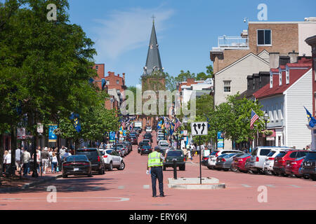 Un agent de circulation dirige le trafic sur la rue principale avec la flèche de l'église Sainte-Anne dans la distance, à Annapolis, MD. Banque D'Images