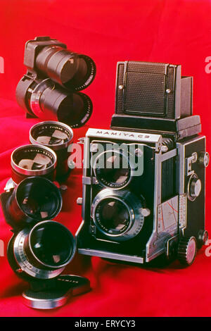 Ancien appareil photo Mamiya C3 interchangeable reflex double objectif et objectifs sur fond rouge Banque D'Images