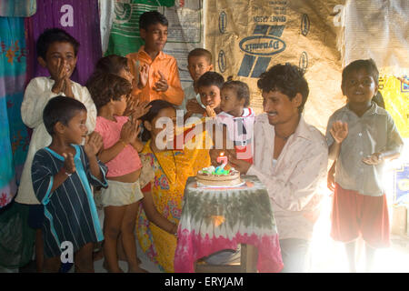 Family celebrating birthday de fille à Malvani Malad de taudis ; ; ; ; Bombay Mumbai Maharashtra Inde Banque D'Images