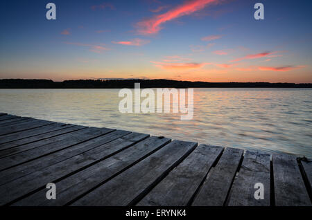 Petite jetée en bois sur grand lac au coucher du soleil en Ukraine Banque D'Images