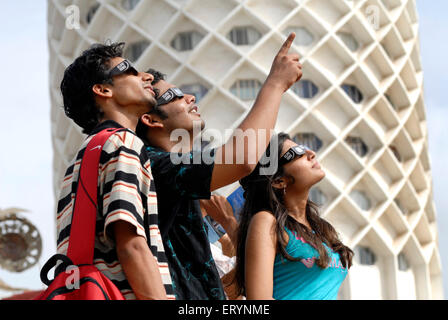 Trois adolescents regarder éclipse solaire partielle par le port d'un filtre de protection au 1er août 2008 à Nehru Centre Bombay Mumbai Banque D'Images