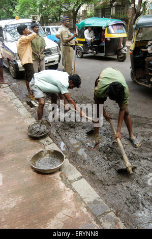 Déposer les ordures et les travailleurs contractuels de la boue sur la route de Bombay Mumbai Maharashtra ; Inde ; Banque D'Images