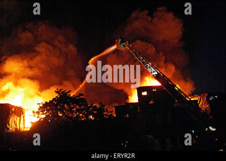 Les pompiers éteindre le feu à l'aide d'un tuba dans Behrampada Bandra taudis ; ; ; Bombay Mumbai Maharashtra Inde 18 juin 2009 ; Banque D'Images