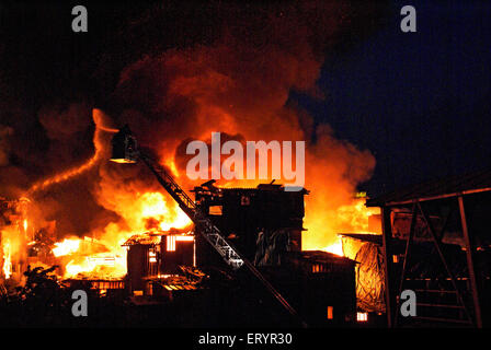 Les pompiers éteindre le feu à l'aide d'un tuba dans Behrampada Bandra taudis ; ; ; Bombay Mumbai Maharashtra Inde 18 juin 2009 ; Banque D'Images