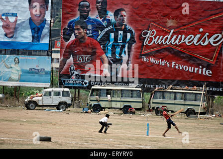 Les enfants jouer au cricket en face de hoarding montrant un joueur de football international 4 mai 2008 PAS DE MR Banque D'Images