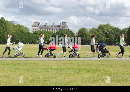 La mère de prendre un cours de conditionnement physique avec les bébés et les tout-petits dans leurs poussettes dans un parc à Londres, Angleterre, RU Banque D'Images