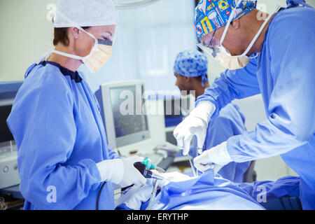 Surgeons performing surgery in operating room Banque D'Images