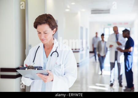 Doctor using digital tablet in hospital corridor Banque D'Images