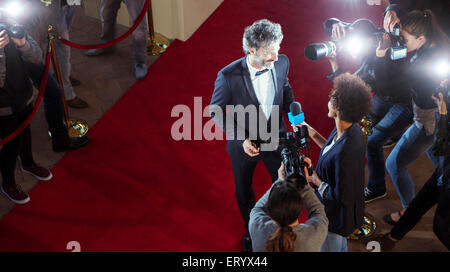 La célébrité d'être interviewé et photographié par des paparazzi at Red Carpet event Banque D'Images