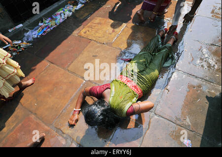 Femme priant, Dandvat Pranam, culte d'obéissance s'étendant sur le trottoir, temple Kalighat Kali, Calcutta, Kolkata, Bengale occidental, Inde, Asie Banque D'Images