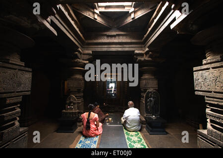 Homme et femme en prière dans l'ancien temple Jain kamal basti à Belgaum Karnataka ; Inde ; Banque D'Images