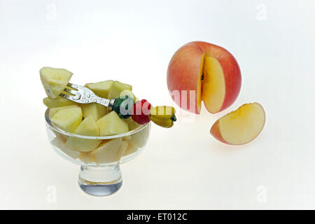 L'Apple Malus pumila morceaux dans un bol de fruits avec des fruits décoratifs et une fourche couper la tranche de pomme Banque D'Images