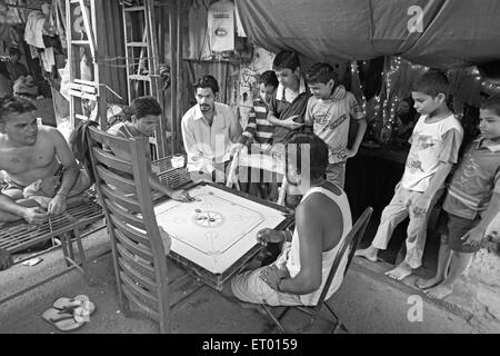 Jouer carrom jeu de plateau , bhagatsingh nagar bidonville ; Wadala ; Bombay , Mumbai ; Maharashtra ; Inde , Asie Banque D'Images