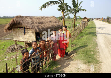 Les enfants en face de l'île majuli bamboo cottages à Assam en Inde Banque D'Images