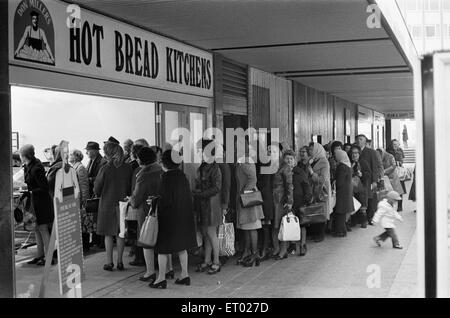 Les années 70 ont été une époque de grèves et, en décembre 1974, la grande boulangerie nationale a décidé de faire de même, en exigeant une augmentation de salaire de 66  %. Le personnel des grandes entreprises et des étagères vides avait dû refuser des dizaines de clients. Les petites boulangeries travaillaient à plein, mais n'ont pu répondre à la demande, car les magasins ont téléphoné pour l'utilisation des fournitures. Les ventes de levure est passé de femme au foyer a décidé de fabriquer leur propre pain. (Photo) de Pain pain chaud à l'extérieur de files d'Cuisines en Corporation Square, Birmingham. 5 mars 1974 Banque D'Images
