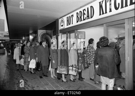 Les années 70 ont été une époque de grèves et, en décembre 1974, la grande boulangerie nationale a décidé de faire de même, en exigeant une augmentation de salaire de 66  %. Le personnel des grandes entreprises et des étagères vides avait dû refuser des dizaines de clients. Les petites boulangeries travaillaient à plein, mais n'ont pu répondre à la demande, car les magasins ont téléphoné pour l'utilisation des fournitures. Les ventes de levure est passé de femme au foyer a décidé de fabriquer leur propre pain. (Photo) de Pain pain chaud à l'extérieur de files d'Cuisines en Corporation Square, Birmingham. 3 Décembre 1974 Banque D'Images
