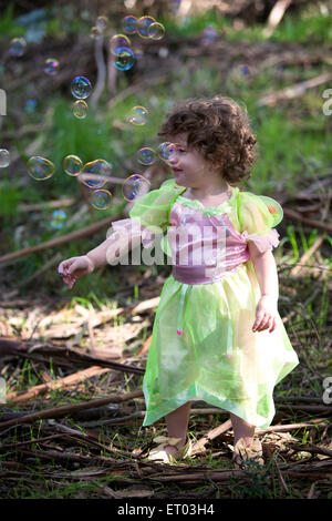 Petite fille en forêt vêtu comme un conte avec des bulles de savon Banque D'Images