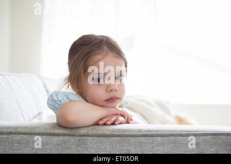 Portrait de jeune fille sérieuse sur canapé Banque D'Images