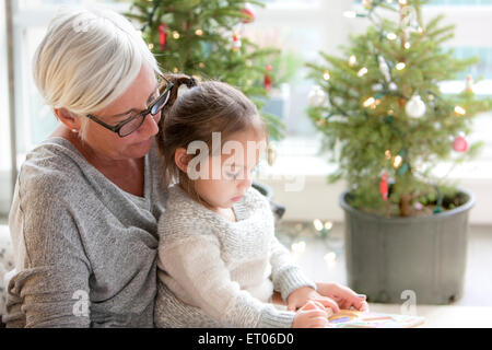 Grand-mère-fille à regarder en face de dessin d'arbres de Noël Banque D'Images