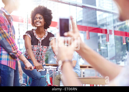 Man photographing women in cafe Banque D'Images