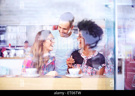 Les amis de rire et de boire du café en café Banque D'Images