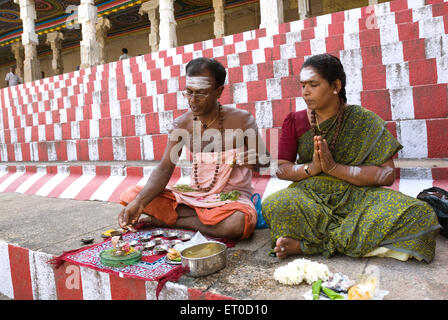 L'exécution de couple sitting on steps pooja shiva Madurai Tamil Nadu ; ; ; l'Inde Août 2009 PAS DE MR Banque D'Images