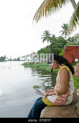 Couple assis sur le mur à l'eau dormante ; ; ; Kuttanad Alleppey Alappuzha Kerala Inde ; M.# 777L Banque D'Images