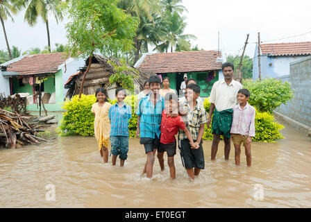 Enfants appréciant les inondations dues à la pluie dans les ghats occidentaux ; Udumalaipettai ; Udumalpet ; Tamil Nadu ; India NOMR Banque D'Images