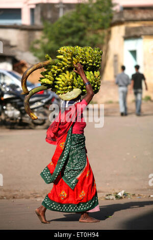 Femme transportant des bananes banane bande sur sa tête dans la ville de Ranchi capitale de Jharkhand Inde Asie Indian fournisseur de fruits vendeur de l'autrure pieds nus asiatique Banque D'Images