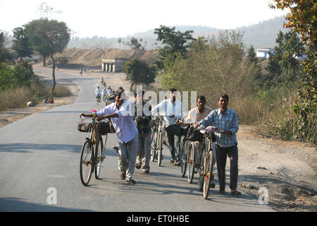 Les travailleurs de mine de charbon transportant bloc de charbon chargés siège arrière de bicyclettes au Jharkhand en Inde ; PAS DE MR Banque D'Images