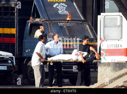 Blessé sur brancard touristiques prises en ambulance à l'extérieur de vieux Taj Mahal Hotel Deccan Mujahideen après l'attaque terroriste de Mumbai  ; Banque D'Images