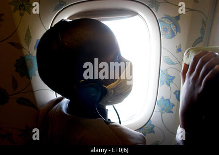 Un jeune patient atteint du cancer à la fenêtre de l'avion au cours d'une manifestation pour les patients atteints de cancer dans la région de Bombay Mumbai Banque D'Images