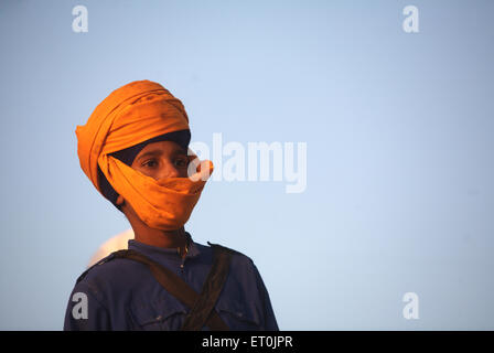 Les jeunes religieux sikh Nihang warrior face couverte d'effectuer les cascades célébration perpétuelle de consécration ; Nanded Guru Granth Sahib Banque D'Images