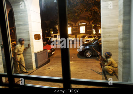 La police de Mumbai à l'abri des coups de feu à l'intérieur des militants Taj Mahal Hotel attaque terroriste par Deccan Mujahedeen ; Bombay Mumbai Banque D'Images