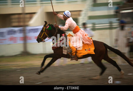 Guerrier Sikh Nihang performing stunts ;consécration célébrations Guru Granth Sikh Khalsa perpétuel terrain de sport Nanded Banque D'Images