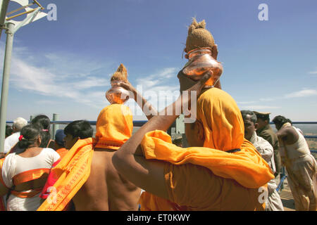 Les dévots exerçant son Mahamasthakabhisheka ustensile en cuivre de coco ; festival ; Shravanabelagola Jain important Hassan ; Karnataka Banque D'Images