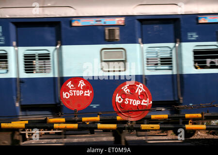 Train passant devant le panneau d'arrêt du passage à niveau, Bhopal, Madhya Pradesh, Inde Banque D'Images