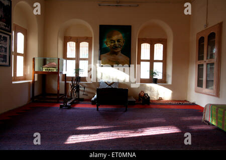 Mahatma Gandhi place assise avec sa grande photographie et son charkha à Satyagraha Ashram fondée en 25 mai 1915 à Kochrab Ashram Ahmedabad Inde Banque D'Images