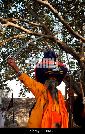 Sikh Nihang ou guerrier dans pagdi ou coiffures exerçant son épée et bâton en bois lors de célébrations de Hola Road Banque D'Images