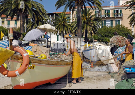 Les pêcheurs avec un bateau de pêche sur la plage de Noli, Riviera di Ponente, Ligurie, Italie Banque D'Images