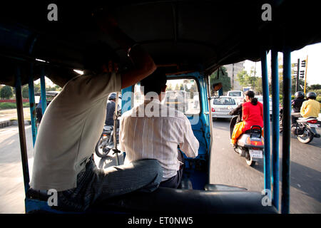 Passager assis derrière conducteur en auto rickshaw à Chandigarh Inde Territoire de l'Union européenne ; Banque D'Images