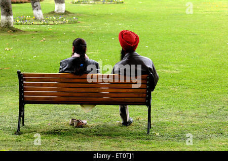 Couple assis sur un banc de jardin ; l'Inde Banque D'Images