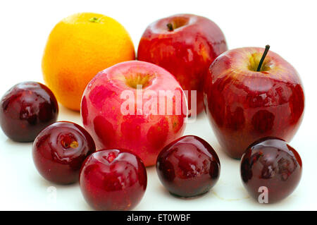 pommes oranges prunes sur fond blanc Banque D'Images