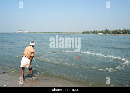 Pêcheur jetant le filet de pêche en mer ; Cochin ; Kochi ; Kerala ; Inde ; Asie Banque D'Images