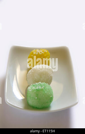 Mithai colorés ; nariyal ka laddoos en plaque rectangle sur fond blanc Banque D'Images